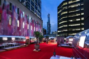 Hotel No في ملبورن: أرضية موكيت حمراء في مدينة بها طاولات ومبنى