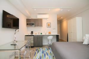 een kleine slaapkamer met een bed en een keuken bij Stylish Studio in Brookline-5min train to Boston.. #2 in Brookline