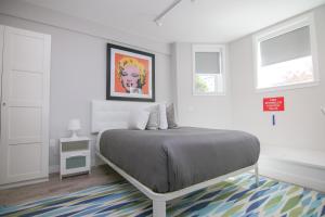 Habitación blanca con cama y alfombra en Stylish Studio in Brookline-5min train to Boston.. #2, en Brookline