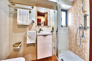 a bathroom with a shower and a sink and a tub at Música Penthouse 360º in Sesimbra