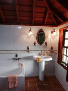 La salle de bains est pourvue d'une baignoire blanche et d'un lavabo. dans l'établissement Große Finca 19Jh, Pool, Terrasse, nahe Santa Cruz, à Santa Cruz de la Palma