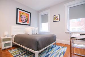 een slaapkamer met een bed en 2 ramen bij A Stylish Stay w/ a Queen Bed, Heated Floors.. #25 in Brookline