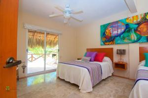 - une chambre avec un lit et un ventilateur de plafond dans l'établissement Rojo Manglar Acapulco, à Acapulco