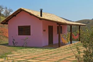 a pink house with a tile roof at Pousada Dona Felicidade in Cunha