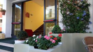 a building with flowers and plants in front of it at Hotel Carmen Viserba in Rimini