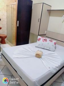 Una cama blanca con dos almohadas encima. en Hotel Central Rosário en Jundiaí