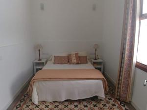 a bedroom with a bed with two tables and a mirror at La Casa del Mar in Garachico