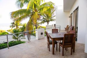 a dining room with a table and chairs on a balcony at Hotel La Casa Cielo solo adultos in El Cuyo