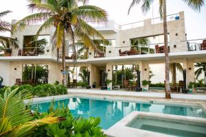 an exterior view of a building with a swimming pool at Hotel La Casa Cielo solo adultos in El Cuyo