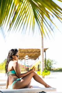 a beautiful young woman sitting on a beach at Hotel La Casa Cielo in El Cuyo