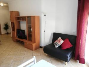 een woonkamer met een zwarte bank en een kast bij Amoreira Alvor - Praia e Piscina in Alvor