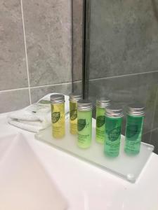 ein Regal mit vier Flaschen Feuchtigkeitscreme auf einem Waschbecken in der Unterkunft exploreNESS Apartment in Inverness