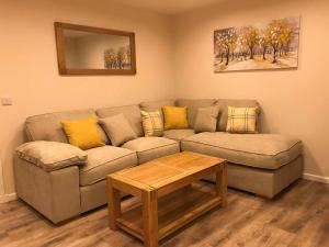 ein Wohnzimmer mit einem Sofa und einem Tisch in der Unterkunft exploreNESS Apartment in Inverness