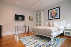 een slaapkamer met een bed en een televisie aan de muur bij A Stylish Stay w/ a Queen Bed, Heated Floors.. #11 in Brookline
