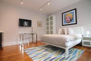 a bedroom with a bed and a television on the wall at A Stylish Stay w/ a Queen Bed, Heated Floors.. #11 in Brookline