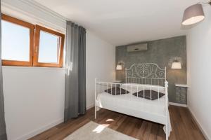 - un lit bébé blanc dans une chambre avec fenêtre dans l'établissement Luxury 1 Bedroom Apartment in Rabac, à Rabac