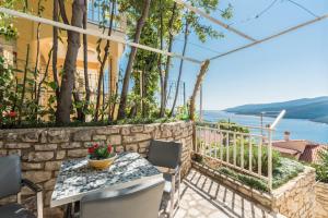 a patio with a table and chairs with a view of the water at Luxury 1 Bedroom Apartment in Rabac in Rabac