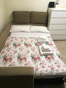 a bed with a floral blanket on top of it at Asher's House Colosseum in Rome