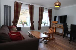 a living room with a couch and a table at Holyrood Skyline Apartment in Edinburgh
