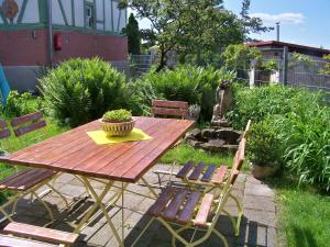 einen Holztisch und Stühle im Garten in der Unterkunft Villa - Sonnenberg in Obersulm