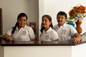 a group of three people standing next to a counter at Hostal Cultural El Telar in San Jacinto