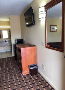 a hotel room with a desk and a mirror at Americas Best Value Inn-Indianola in Indianola