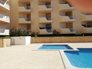 een appartement met een zwembad voor een gebouw bij Amoreira Alvor - Praia e Piscina in Alvor
