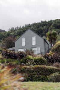 a house on the side of a hill with trees at Maruia River Retreat in Shenandoah
