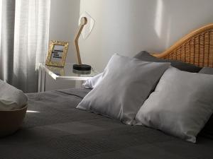 un letto con cuscini bianchi e un tavolo con una lampada di MARZEC Apartamenty a Gniezno