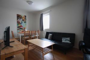 a living room with a black couch and a table at Selfell Guesthouse by Stay Iceland in Kálfafell