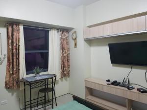 a small room with a small table and a television at Horizon 101 Cebu by KC Condo in Cebu City