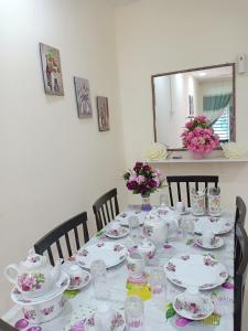 een tafel met borden en bekers en een spiegel bij HOMEMuslim GAMBANG in Kampong Pohoi