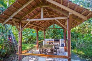 a wooden gazebo with a wooden table and chairs at Cabinas Iguana Cahuita in Cahuita