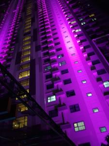ein Gebäude, das nachts in lila leuchtet in der Unterkunft Horizon 101 Cebu by KC Condo in Cebu City