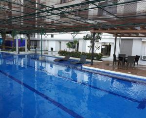 a large blue swimming pool with chairs and a table at Horizon 101 Cebu by KC Condo in Cebu City