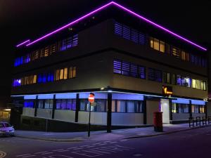 a building with purple lights on the side of it at Queen Stay Apartments in Sheffield