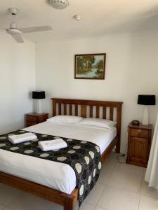 a bedroom with two beds and two night stands at Burleigh Gardens North Hi-Rise Holiday Apartments in Gold Coast
