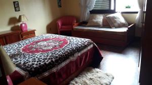 a bedroom with a bed and a chair and a window at apto centro de gramado in Gramado