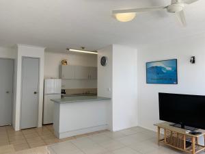 sala de estar con TV y cocina en Burleigh Gardens North Hi-Rise Holiday Apartments, en Gold Coast