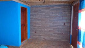 una camera con pareti blu e un muro di mattoni di ZIRAHUÉN CUIN Habitaciones Rústicas a Zirahuén