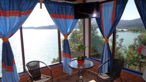 a screened in porch with a view of the water at ZIRAHUÉN CUIN Habitaciones Rústicas in Zirahuén