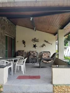une terrasse avec des chaises, des tables et des oiseaux sur le mur. dans l'établissement Casa Ilha de Itaparica, à Itaparica Town