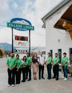 een groep mensen die voor een gebouw staan bij Golden Village Lodge in Golden