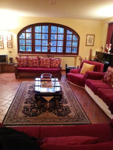 ein Wohnzimmer mit roten Sofas und einem Couchtisch in der Unterkunft Gli Aceri B&B in Arcola