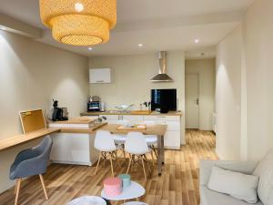 eine Küche und ein Wohnzimmer mit einem Tisch und Stühlen in der Unterkunft Esprit Cosy sur plateau central in Clermont-Ferrand