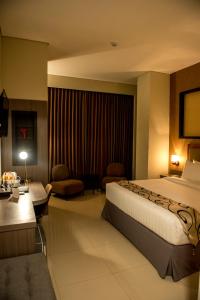 a hotel room with a bed and a living room at Grand Padis Hotel in Bondowoso