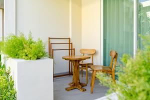 a table and chairs on a porch with plants at Anja Jimbaran in Jimbaran