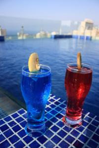 Midtown Hotel & Suites في بيروت: كأسان يجلسان على طاولة بجوار الماء