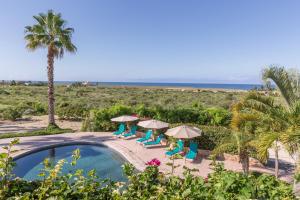 una piscina con sombrillas y sillas y la playa en Serendipity, en Todos Santos
