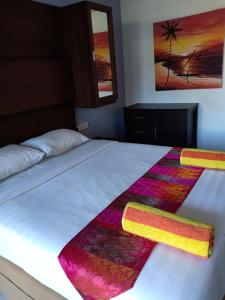 Un dormitorio con una cama con una manta de colores. en Tropica Gili Total Body Fit, en Gili Trawangan